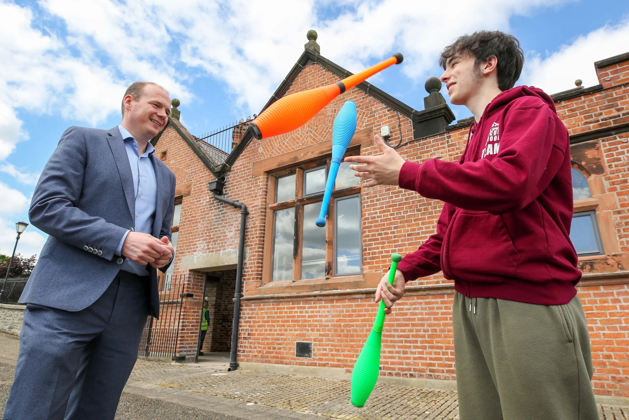 Minister Gordon Lyons chatting to young IYSC juggler Aidan outside the Cathedral School on the City Walls